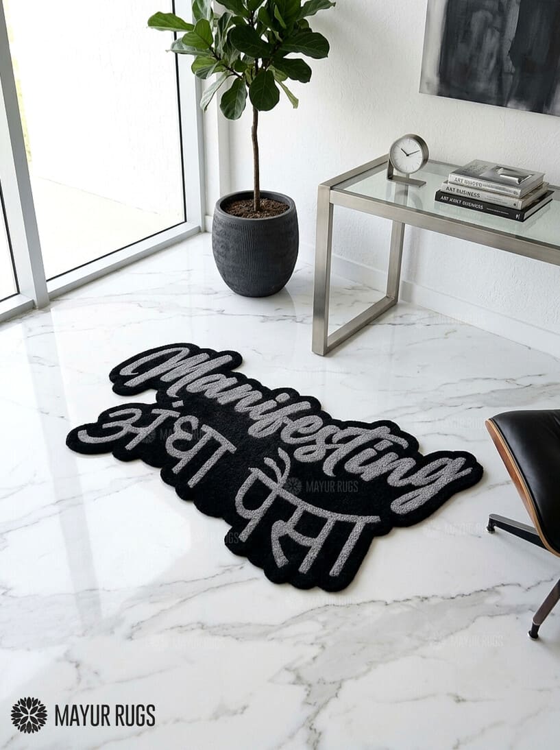 Manifesting Andha Paisa hand-tufted custom wool rug featuring bold grey English and Hindi typography on a black background, designed for desi-inspired bedrooms, gaming rooms, and modern workspaces by Mayur Rugs.