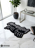 Manifesting Andha Paisa hand-tufted custom wool rug featuring bold grey English and Hindi typography on a black background, designed for desi-inspired bedrooms, gaming rooms, and modern workspaces by Mayur Rugs.