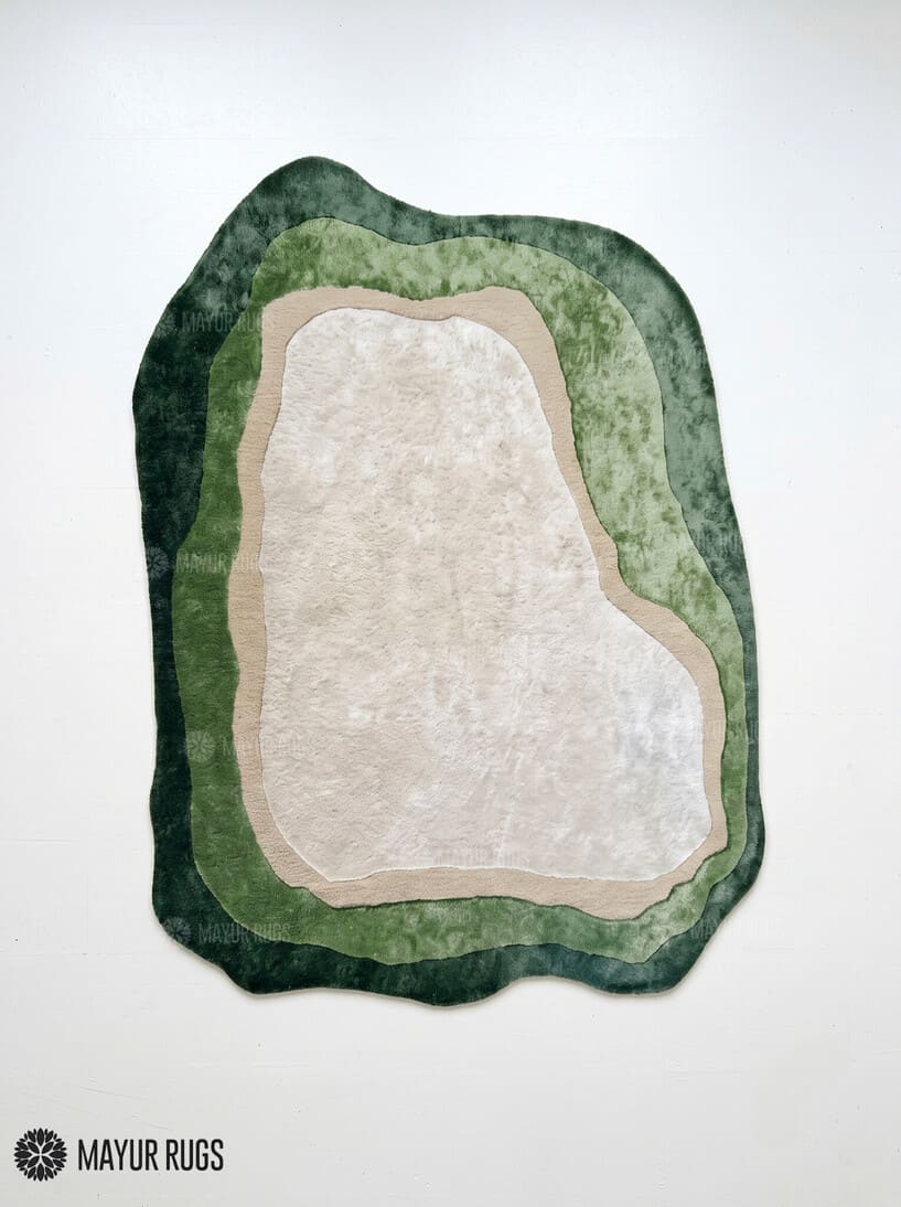 Forest green silk and wool hand-tufted rug with an irregular organic shape, layered sage and olive green borders, a warm beige outline, and a soft ivory center by Mayur Rugs.