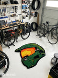 Custom-shaped green sci-fi Spartan helmet rug featuring an orange-gold visor, black outlines, and angular armor details inspired by Halo's Master Chief.