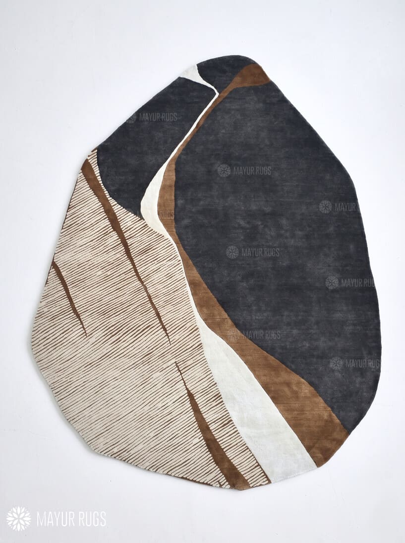 Modern abstract rug with an irregular organic shape, charcoal grey sections, taupe and brown curves, ivory bands, and fine linear detailing by Mayur Rugs.
