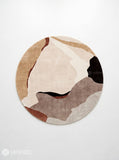 Round abstract area rug featuring flowing organic shapes in beige, ivory, taupe, chocolate brown, and rust tones by Mayur Rugs.