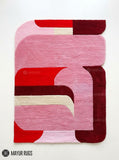 Pink Mirage abstract area rug featuring pink, red, burgundy, and ivory curved geometric shapes in a contemporary color-blocked design by Mayur Rugs.