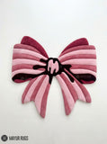 Pink ribbon bow 3D hand-tufted custom wool rug featuring layered blush, rose, dusty pink, and burgundy ribbon shapes with a sculpted center knot for coquette and feminine décor by Mayur Rugs.