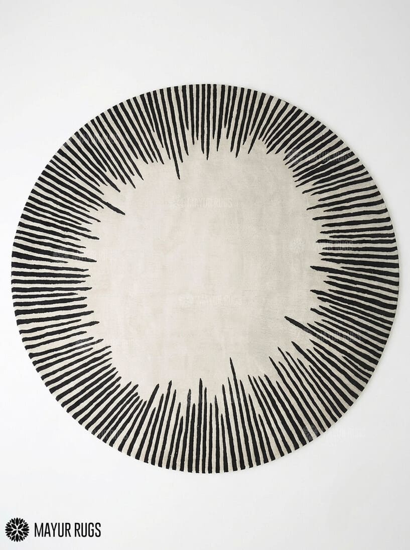Round ivory area rug with radiating black sunburst lines in varied lengths, creating a bold minimalist monochrome design by Mayur Rugs.