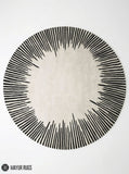 Round ivory area rug with radiating black sunburst lines in varied lengths, creating a bold minimalist monochrome design by Mayur Rugs.