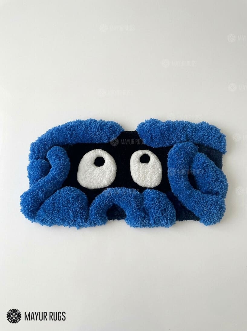 Tangela inspired Pokémon 3D hand-tufted keyboard rug featuring a blue tangled-vine character design with large white eyes and raised plush detailing for gaming and anime desk décor by Mayur Rugs.