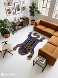Tibetan tiger-inspired hand-tufted custom rug in blue, black, and golden beige featuring a full-body tiger design, curved tail, extended paws, and detailed tiger face by Mayur Rugs.